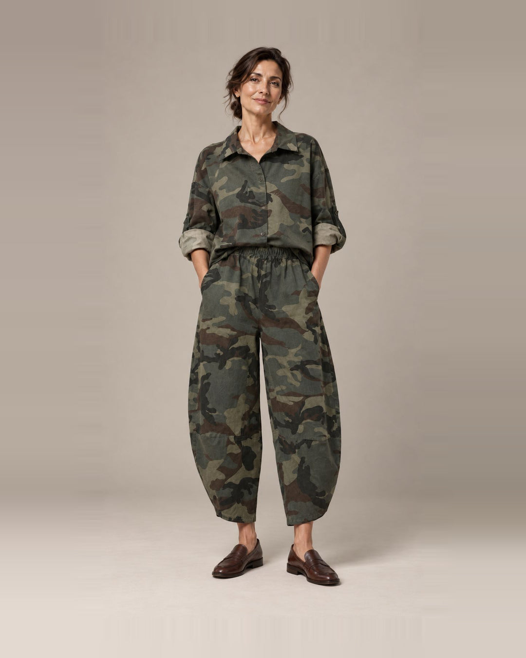 Modelo con conjunto de camuflaje verde para mujer, camisa de manga larga y pantalón amplio, vista frontal.
