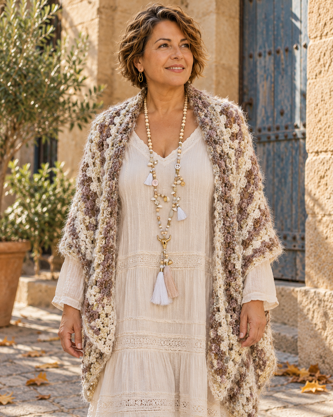 Collar largo boho calavera de toro · blanco y dorado, llevado por una modelo con vestido claro y prenda de crochet