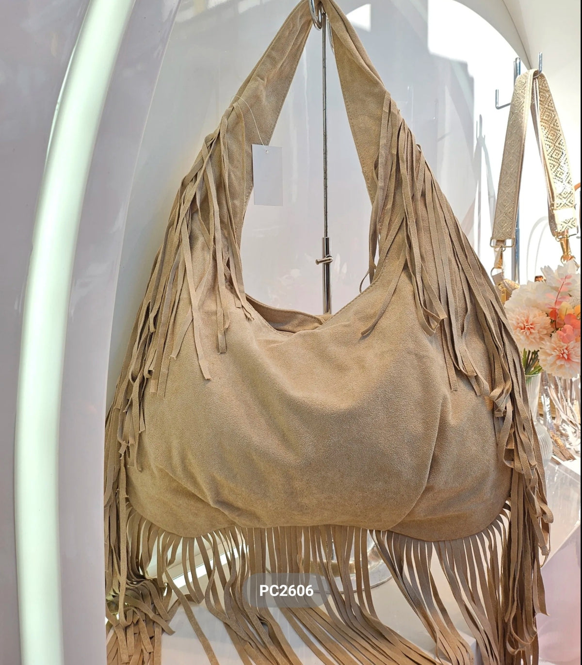 Bolso de hombro de piel con flecos en el asa y la base, color beige, vista del producto original.