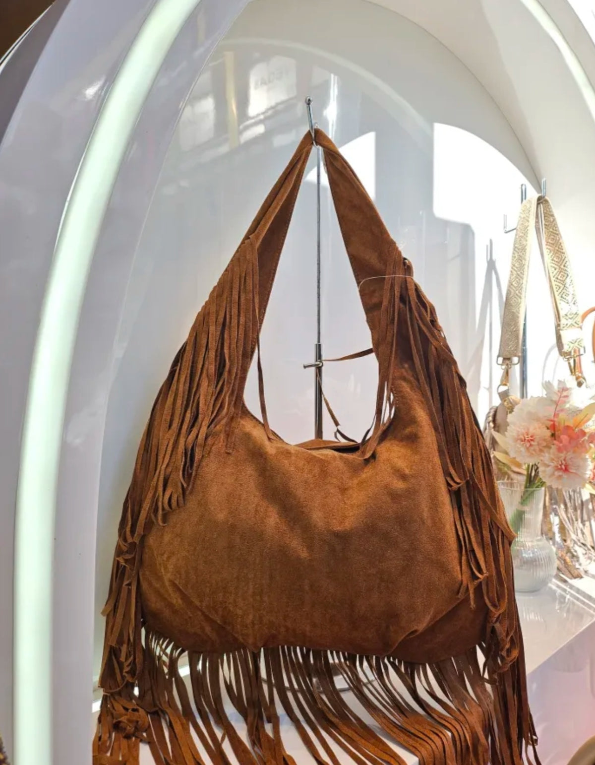 Bolso de hombro de piel con flecos en el asa y la base, color camel, vista del producto original.