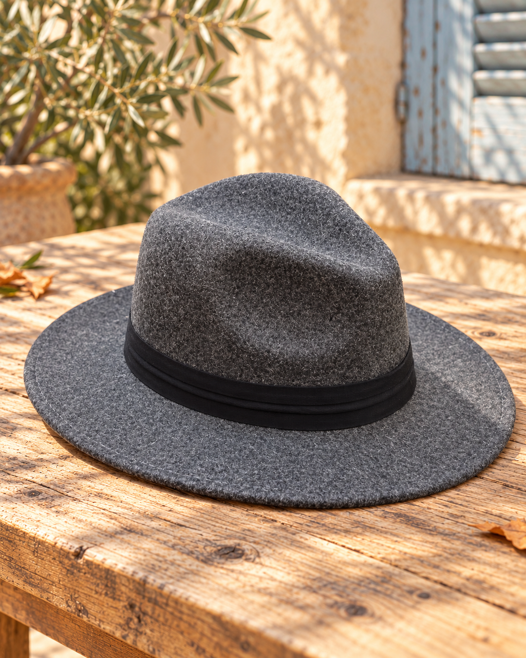 Sombrero fedora boho gris con cinta, bodegón del producto sobre madera